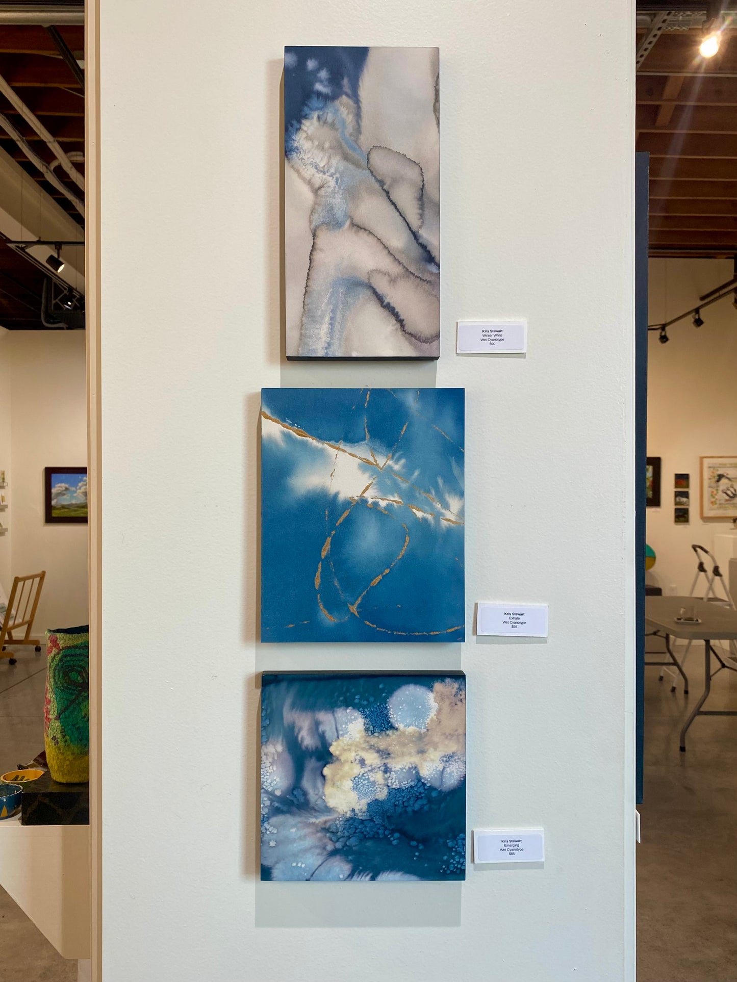 Artistic wall display with abstract paintings in an art gallery setting.