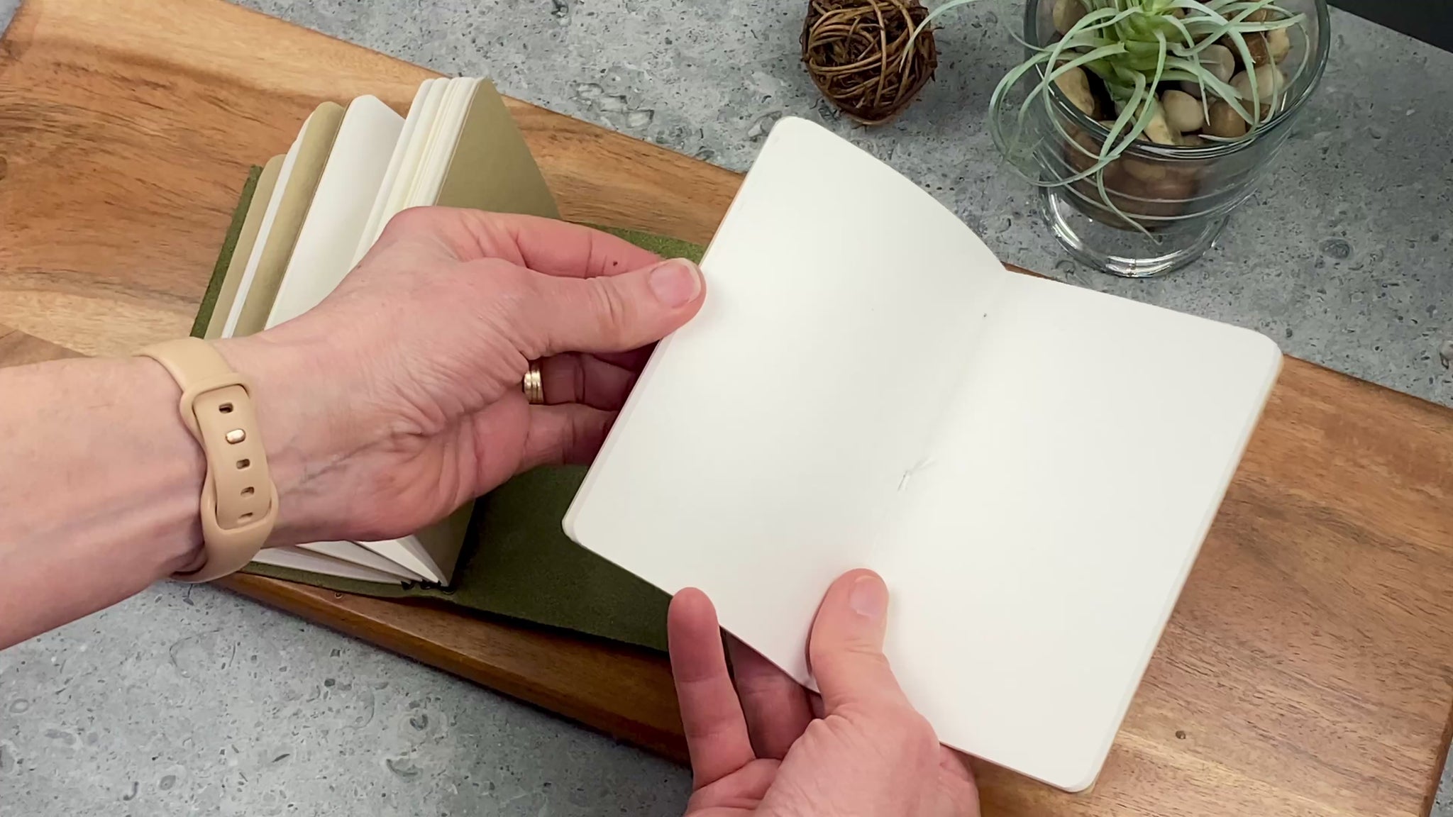 Pocket size refill booklet being inserted into a leather journal cover